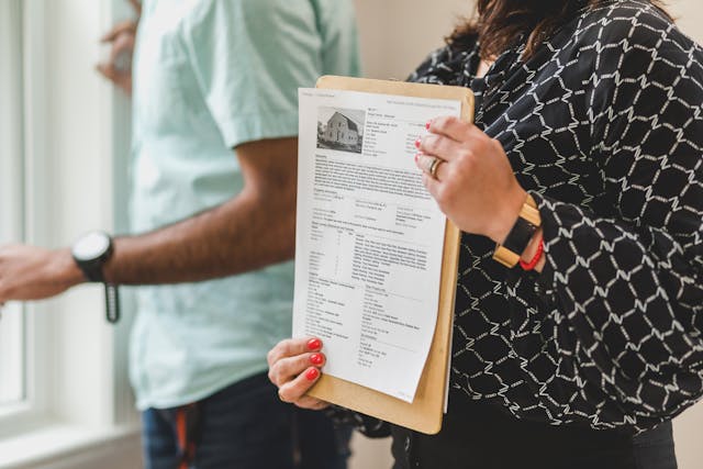 a-person-holding-a-paper-with-a-picture-of-a-house